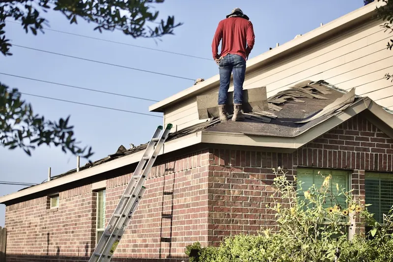 Professional roofer working on a residential roof in Arvin